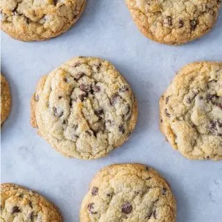 Freshly baked chewy chocolate chip cookies on baking sheet.