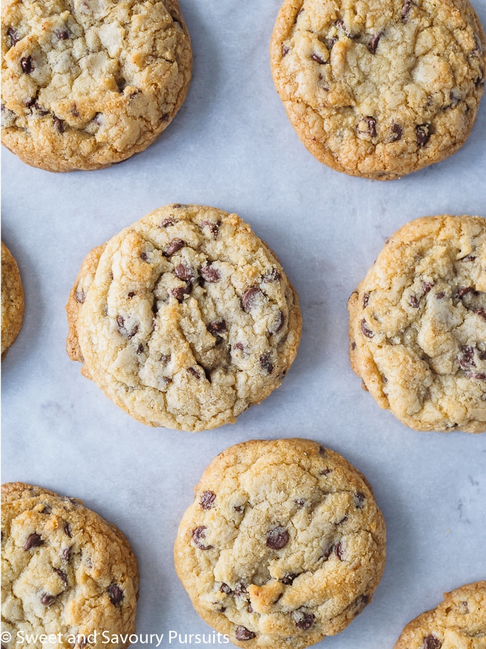 Freshly baked chewy chocolate chip cookies on baking sheet.