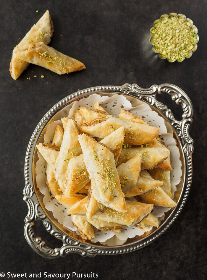 Rolled Baklava fingers piled on serving dish.