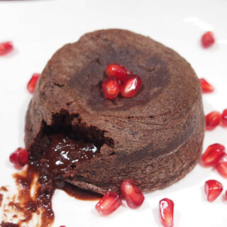 One Molten Chocolate Cake with view of oozing chocolate coming out of it.