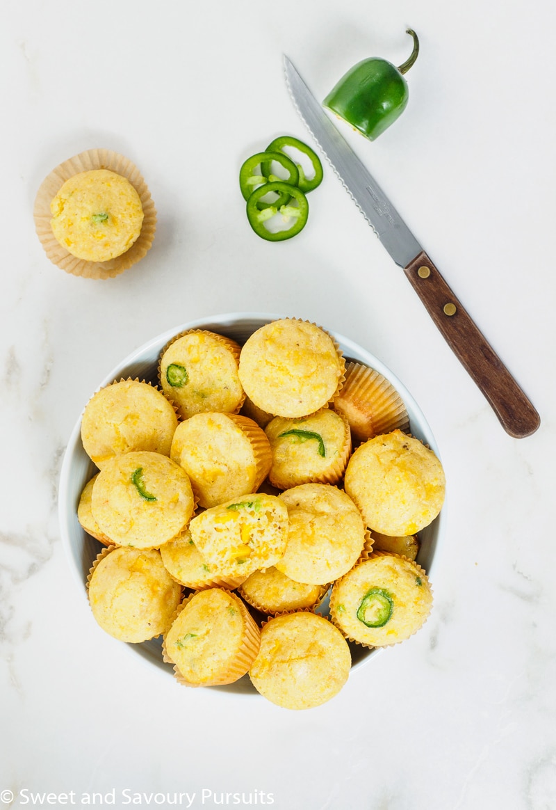 Freshly baked Mini Cornbread Muffins with corn and jalapeño in bowl.
