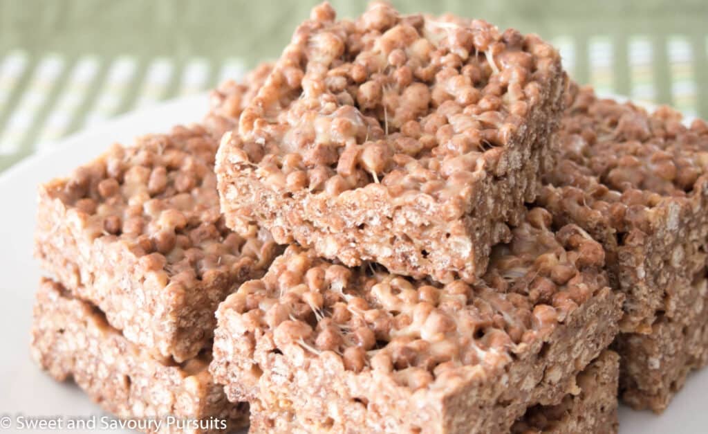 Dish of stacked squares made from Cocoa Quinoa Puff cereal and peanut butter.