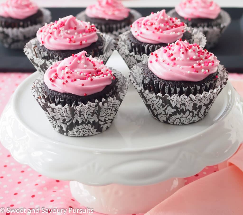 Chocolate beet cupcakes with cream cheese frosting on cake stand.