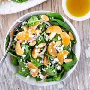 Bowl of spinach and clementine salad.