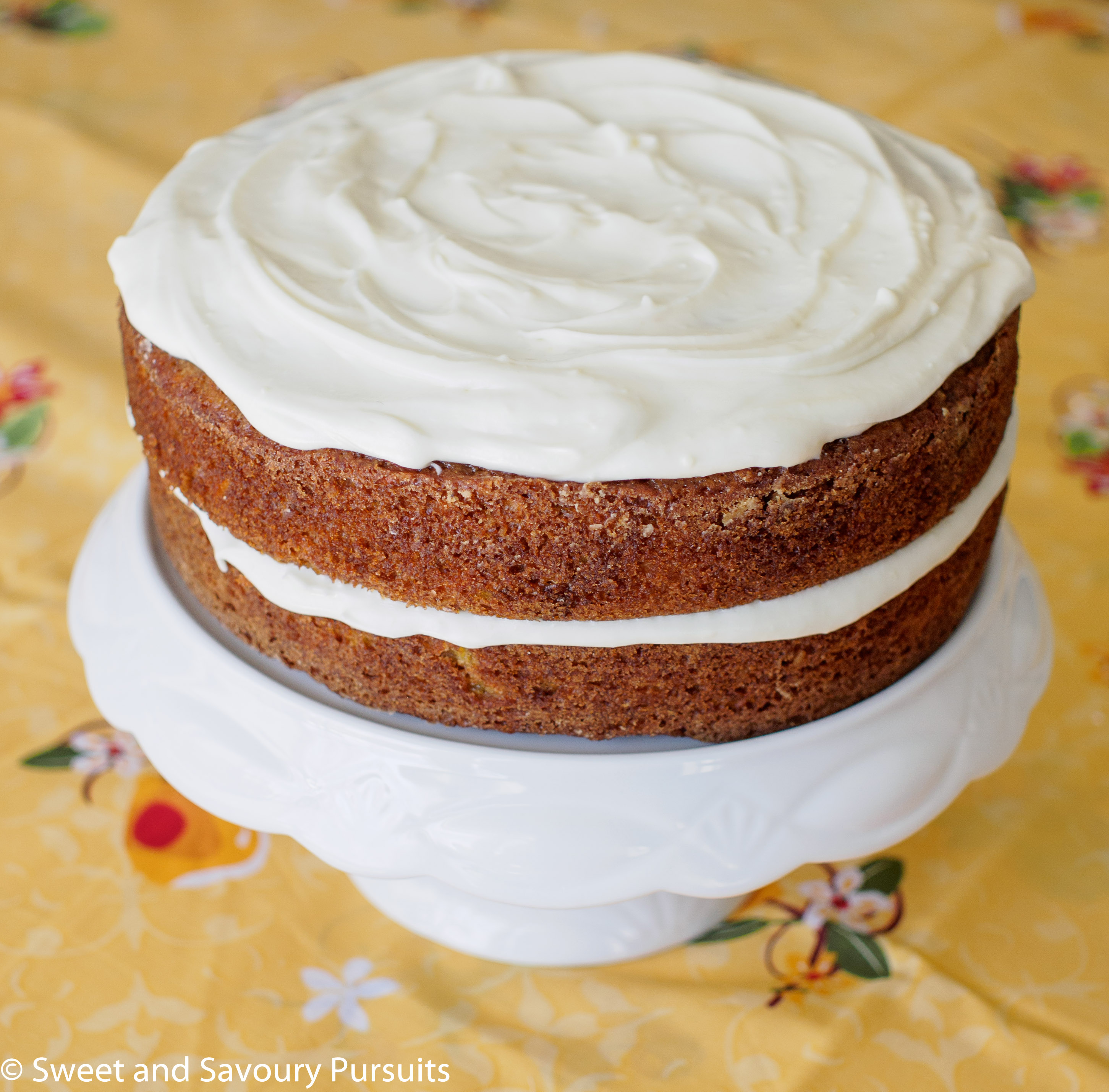 Carrot Cake with Cream Cheese Frosting on cake stand.