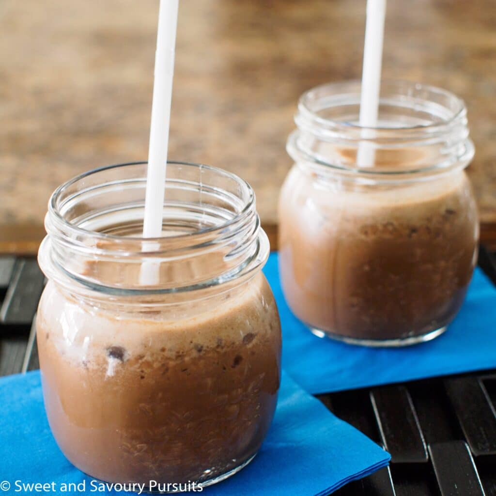 Coffee smoothie served in small mason jars.