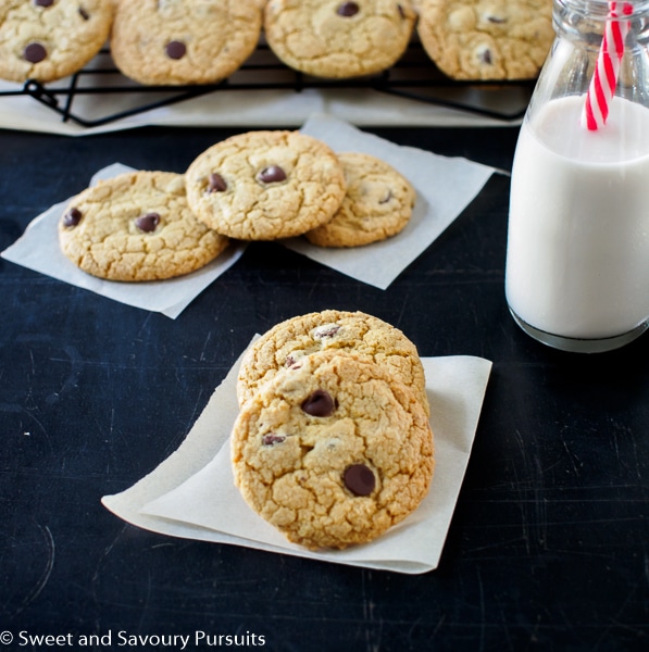 Quinoa Chocolate Chip Cookies on black board with a small bottle of milk.