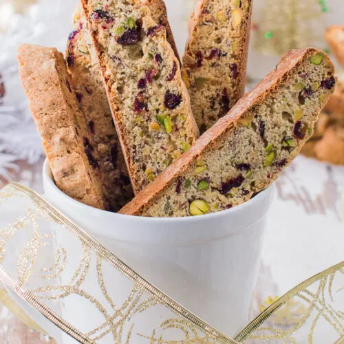 Pistachio and Cranberry Biscotti displayed in mug.