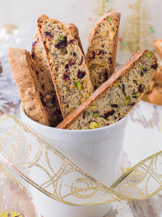 Pistachio and Cranberry Biscotti displayed in mug.