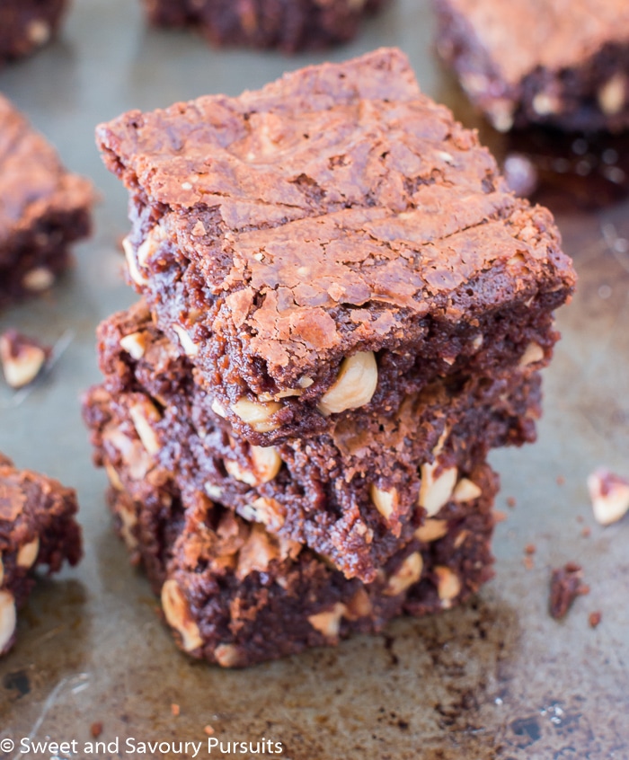 Three Nutella hazelnut brownies stacked on top of each other on a baking tray.