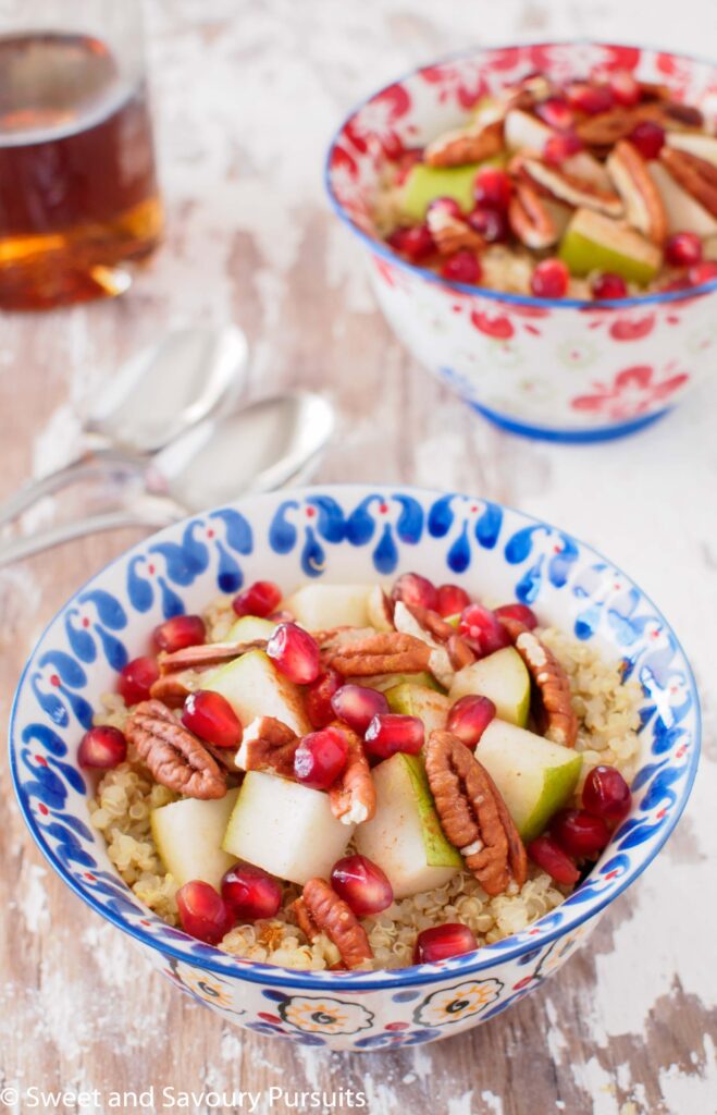 Pear, Pommegranate and Pecan Quinoa Breakfast Bowl served with maple syrup.