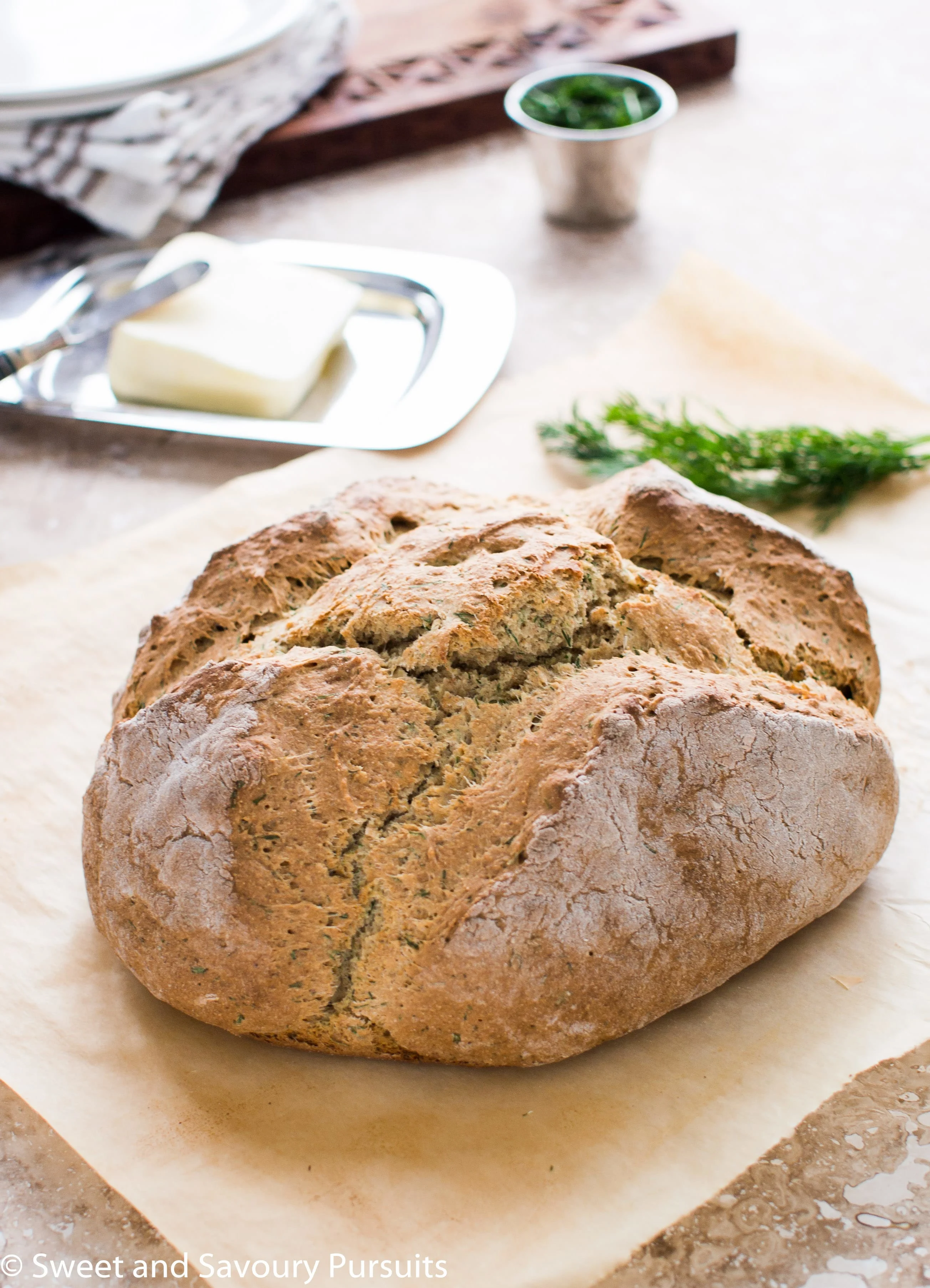 Loaf of Irish Soda Bread with Dill on parchment paper.