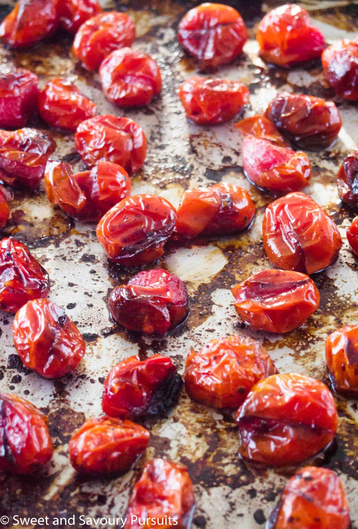 Roasted tomatoes on baking sheet.