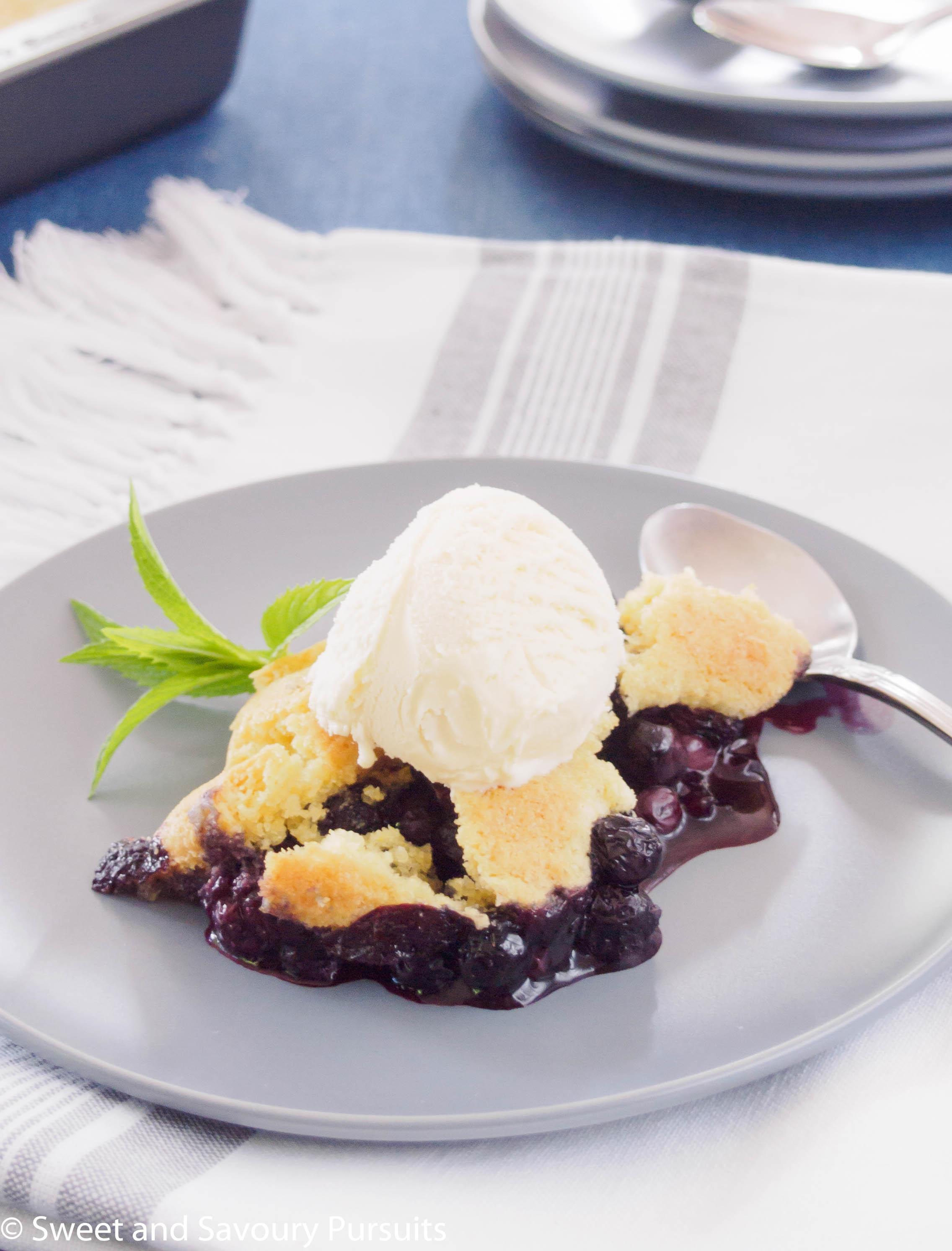 Blueberry cobbler topped with a scoop of vanilla ice cream.