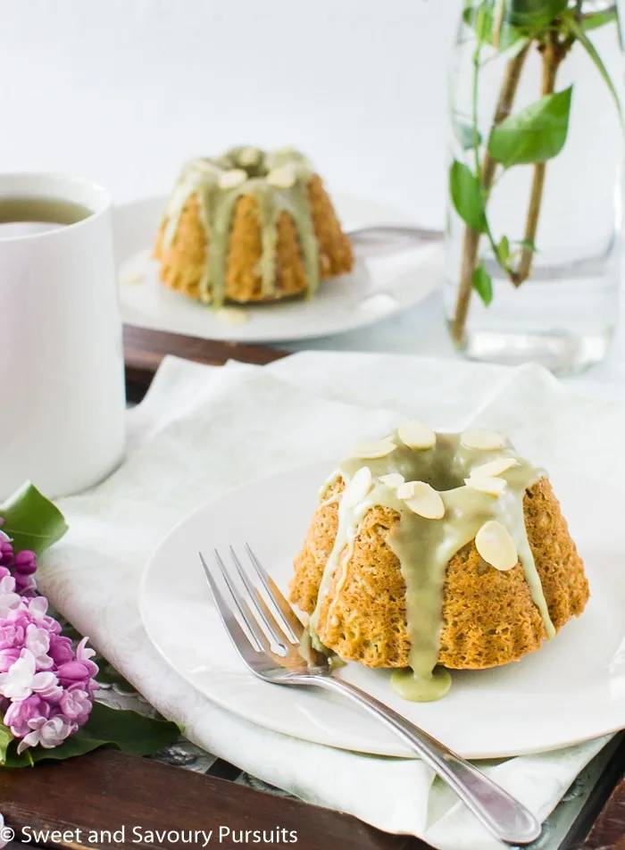 Mini Almond and Matcha Cakes on plates served with a cup of green tea.