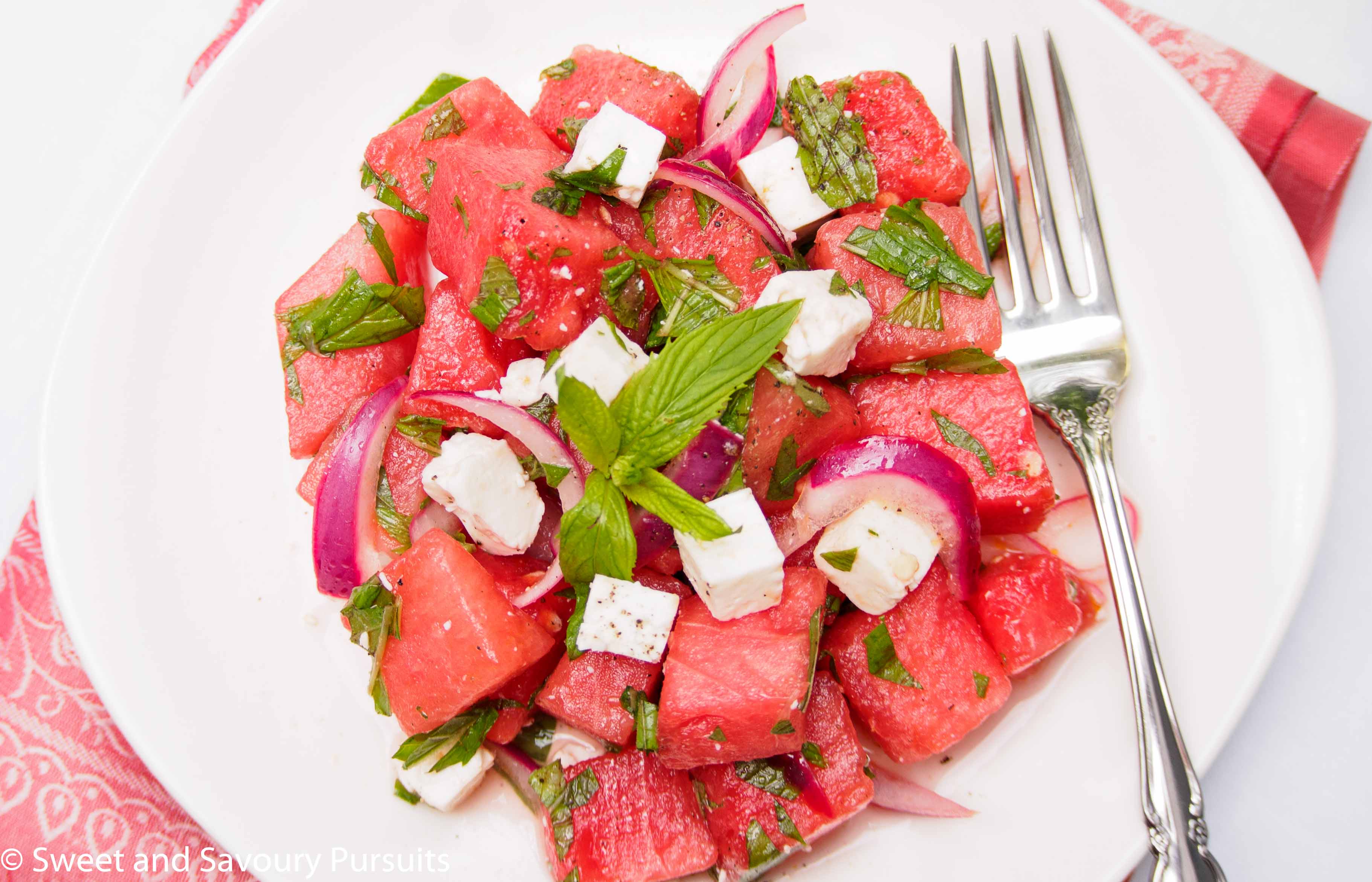 Watermelon Feta Salad topped with fresh mint and served on dish.
