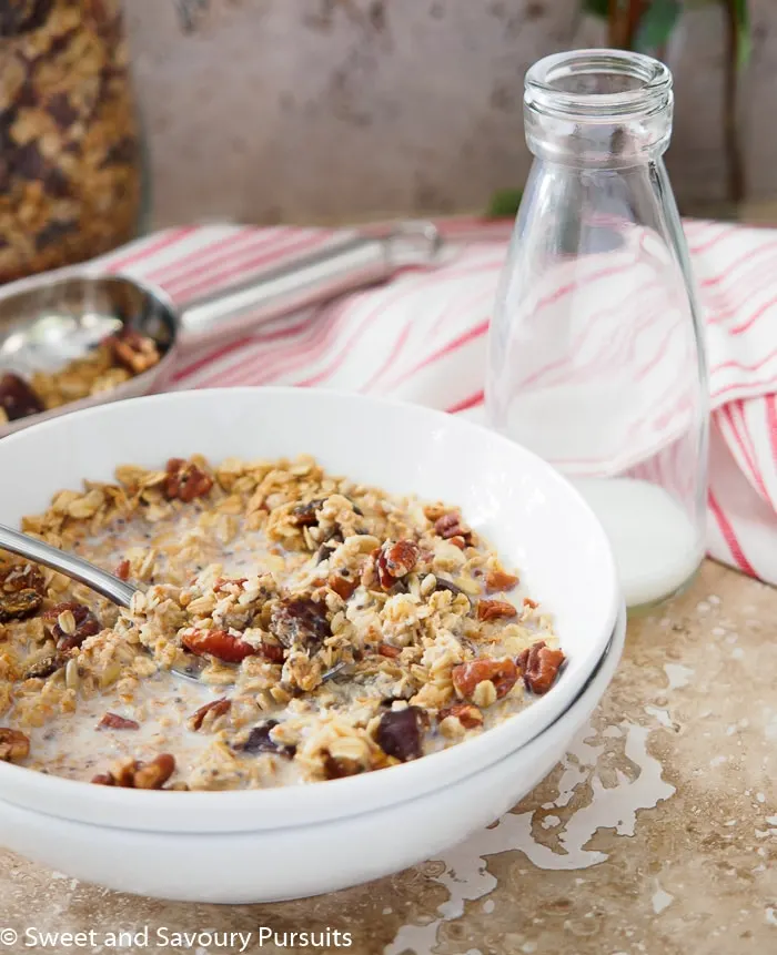 Bowl of Maple Pecan Granola served with milk.