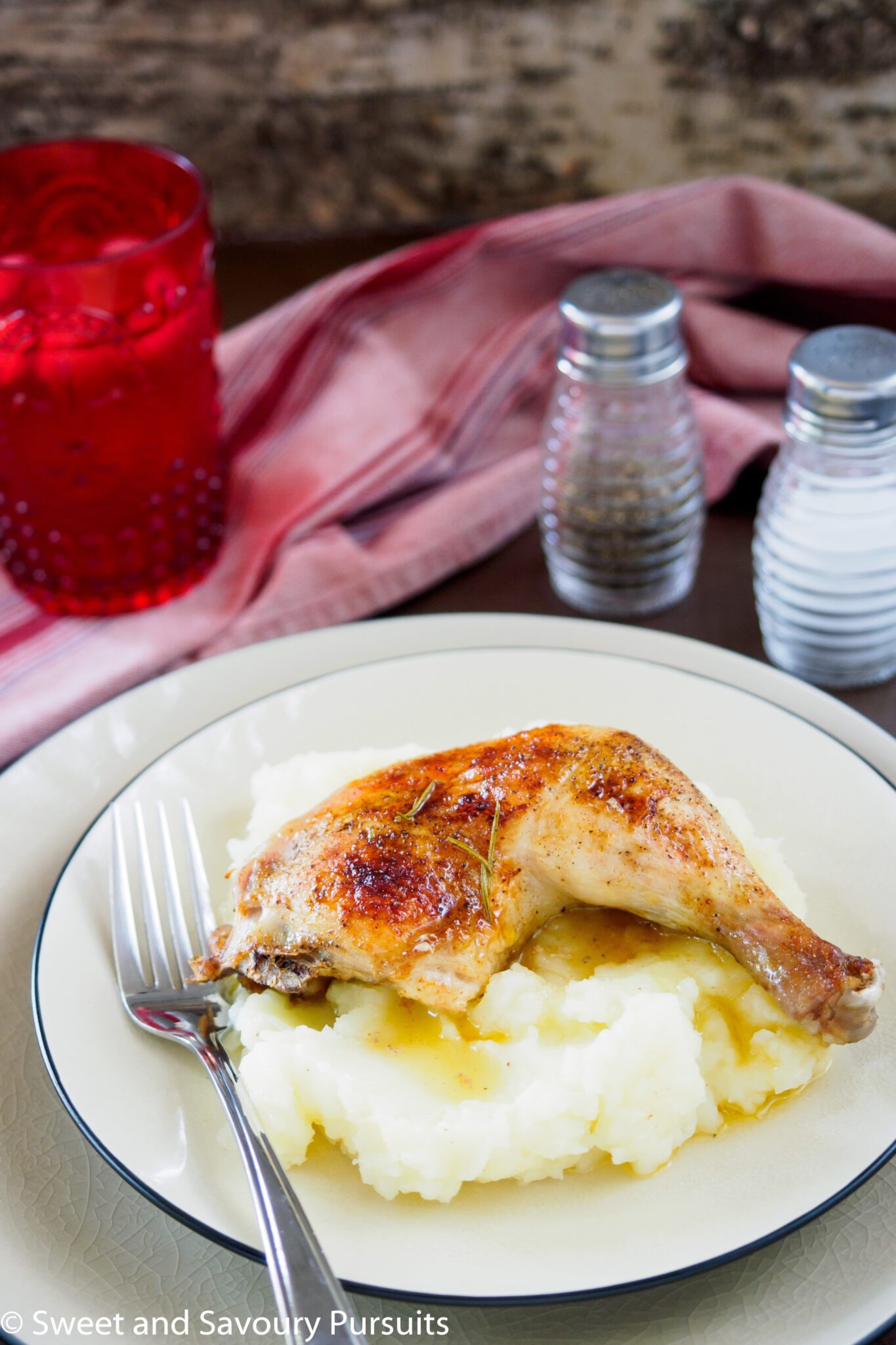 Roast chicken leg served on top of mashed potatoes.