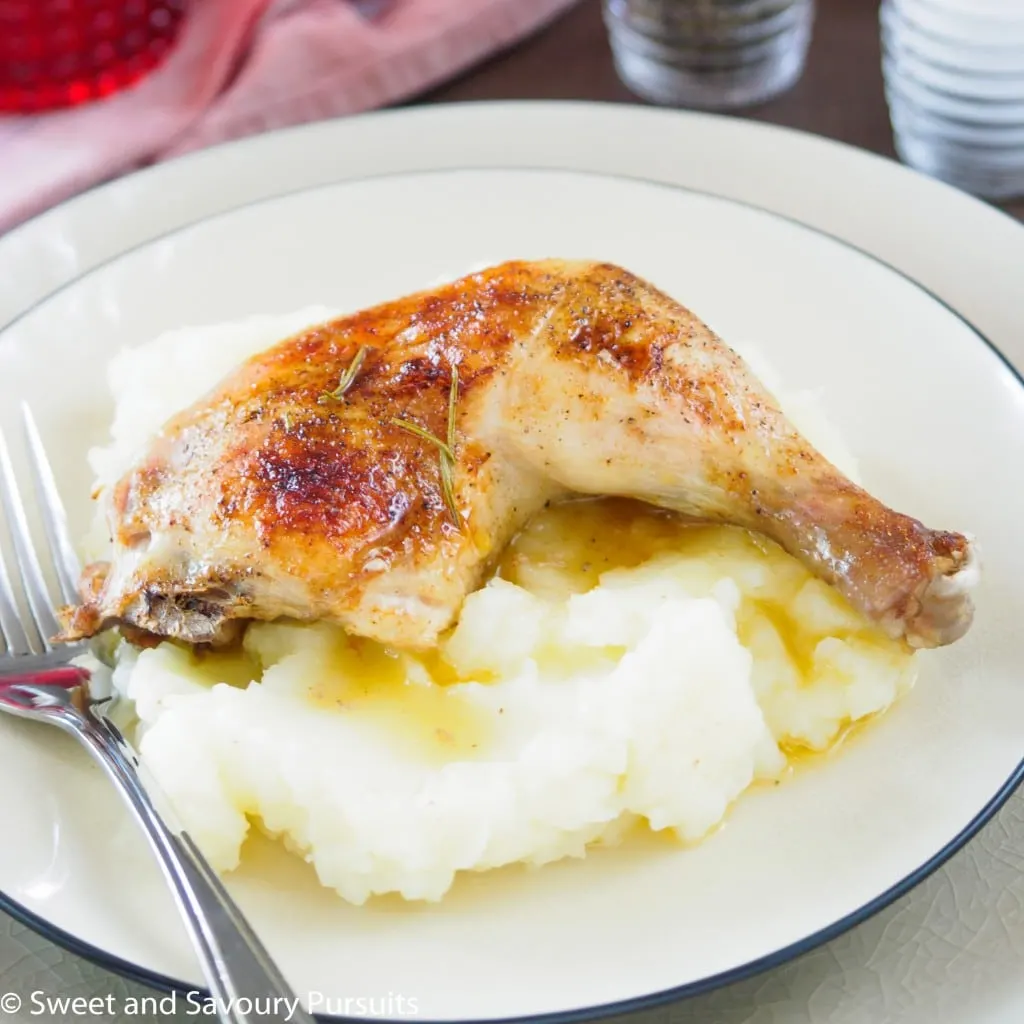 Roasted chicken thigh over mashed potatoes.