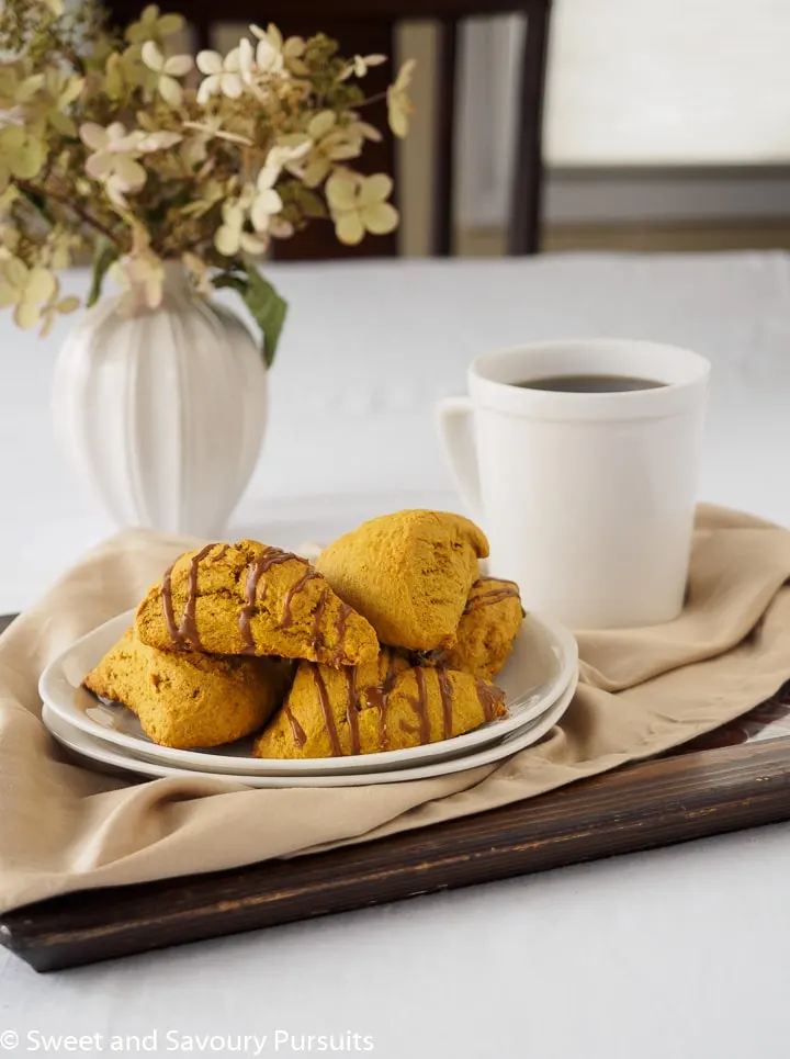 Plate of pumpkin scones served with a cup of coffee.