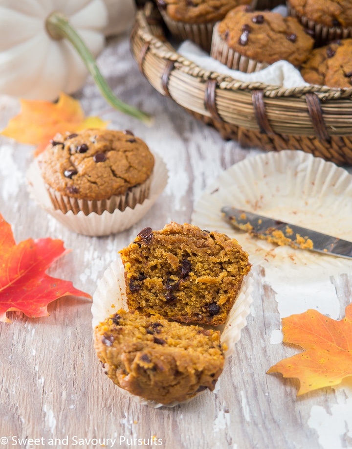Pumpkin Chocolate Chip Muffin cut in half with more muffins in the background.