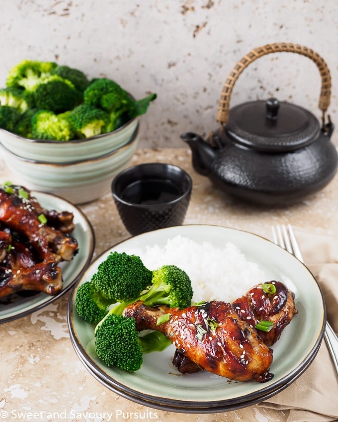 Sticky Chicken Drumsticks on dish with rice and broccoli.