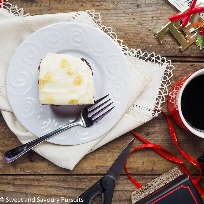 Slice of gingerbread cake topped with cream cheese frosting.