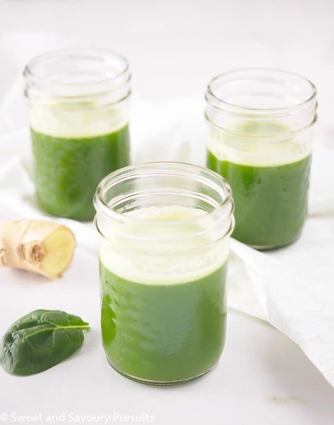 Pineapple Spinach Juice with Ginger served in small mason jars.