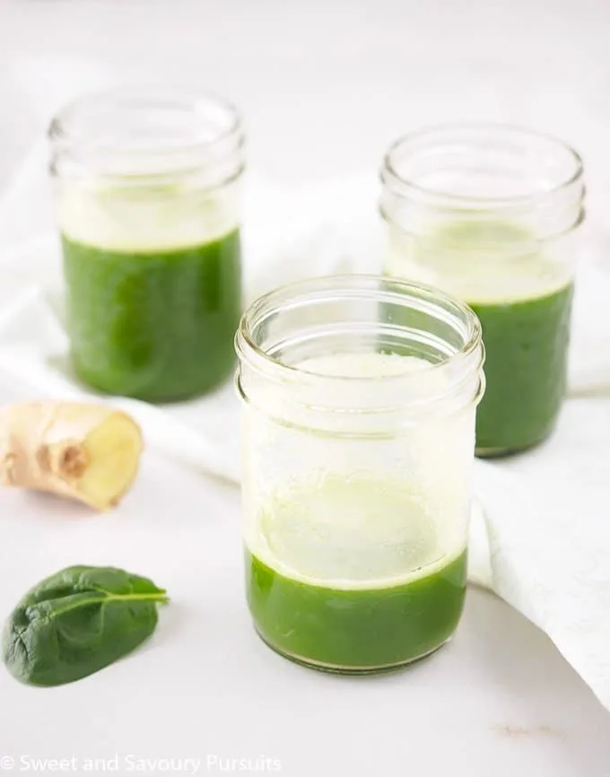 Pineapple Spinach Juice with Ginger served in small mason jars.