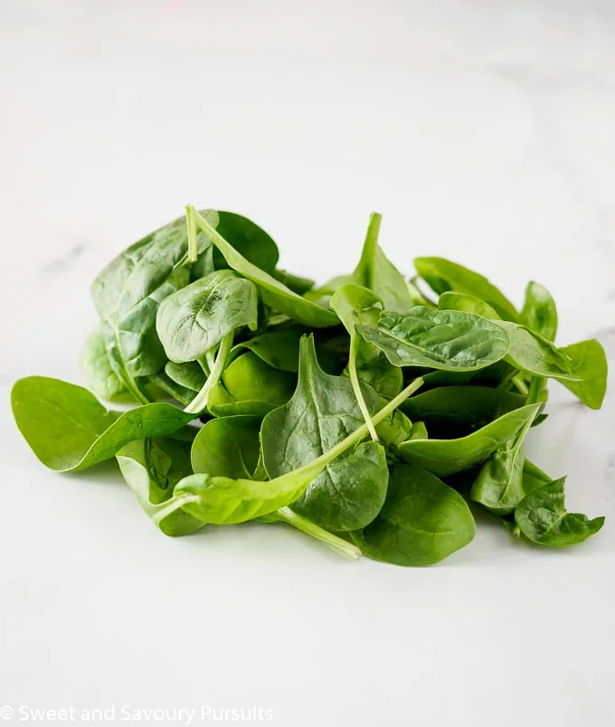 Bunch of baby spinach on board.