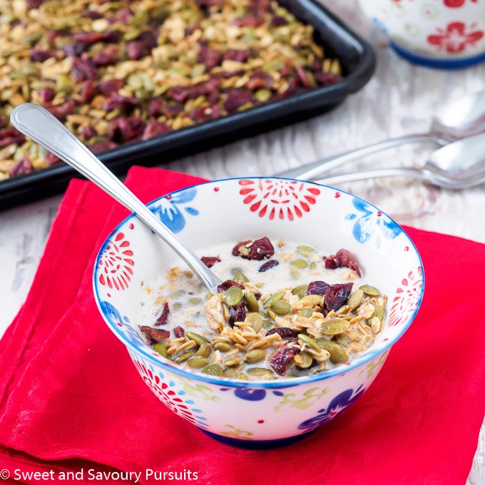 Bowl of nut-free Healthy Pumpkin Seed Granola topped with milk.