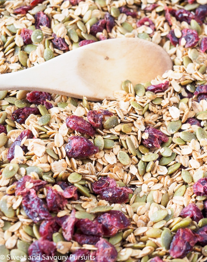 Pumpkin Seed Granola on baking sheet with wooden spoon.