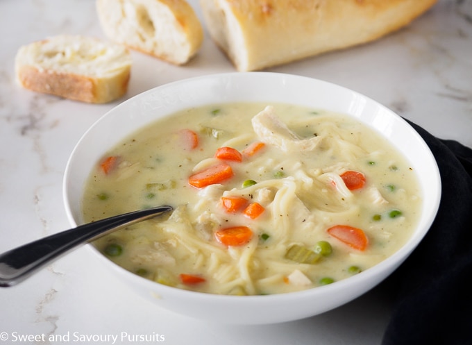 Bowl of creamy chicken noodle and vegetable soup.