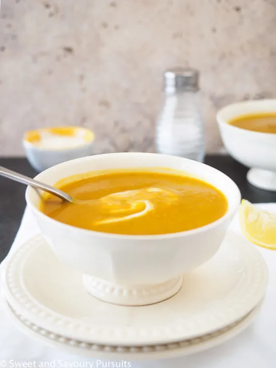 Close-up of a bowl of Sweet Potato and Red Lentil Soup with a swirl of yogurt.