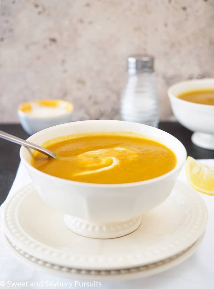 Close-up of a bowl of Sweet Potato and Red Lentil Soup with a swirl of yogurt.