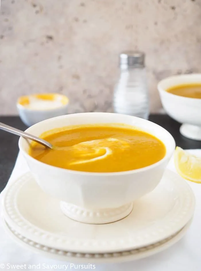 Close-up of a bowl of sweet potato red lentil Soup with a swirl of yogurt.