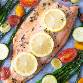 Baked Rainbow Trout Fillet with asparagus, cherry tomatoes and zucchini baked all on one tray.