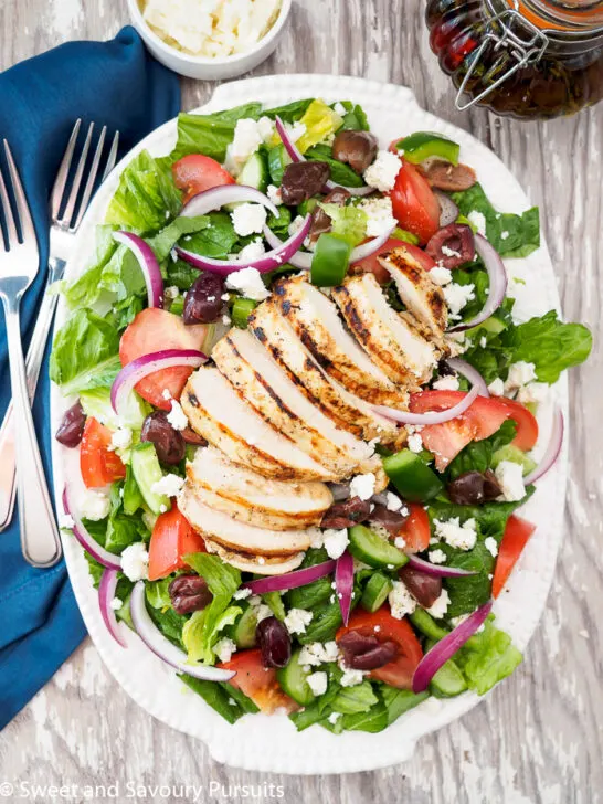 Greek Salad with Grilled Chicken served on platter.