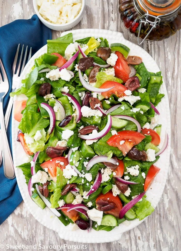 Greek style salad served on large white oval plate.