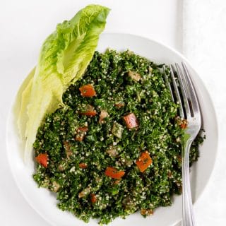 Lebanese Tabbouleh salad served in bowl with romaine lettuce on the side.