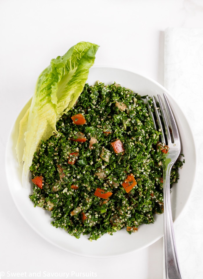 Bowl of tabbouleh salad served with a wedge of romaine lettuce.