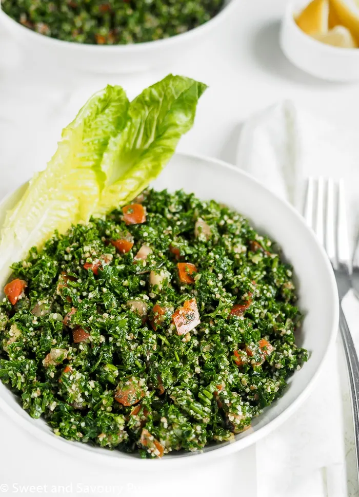 Lebanese Tabbouleh served in bowl with romain lettuce leaves.