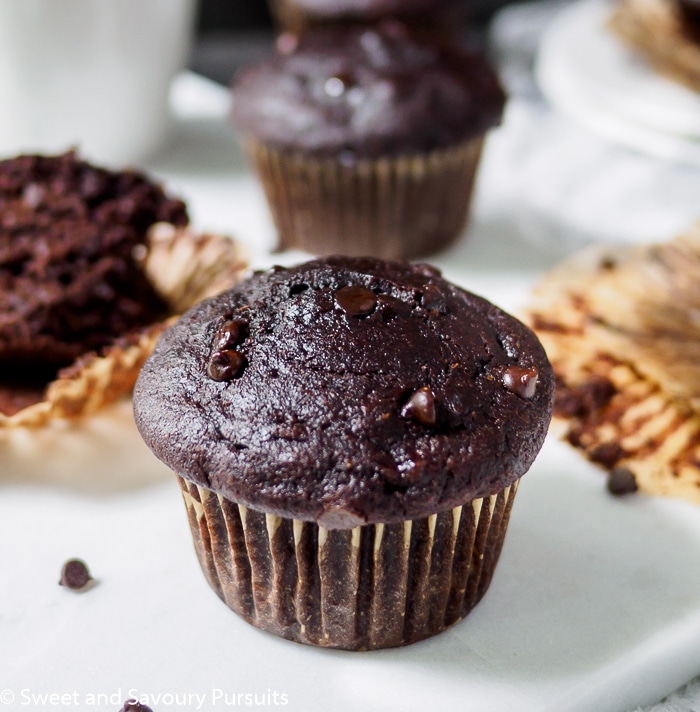 Close-up of a Double Chocolate Banana Muffin with more muffins in background.