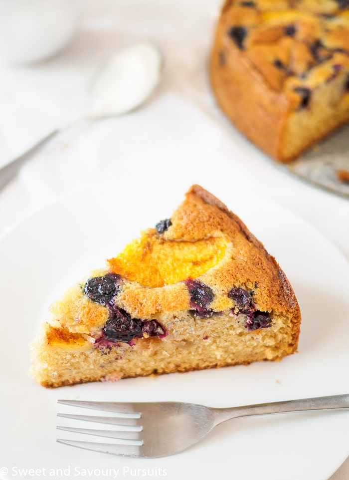 Slice of Peach and Blueberry Cake on plate.