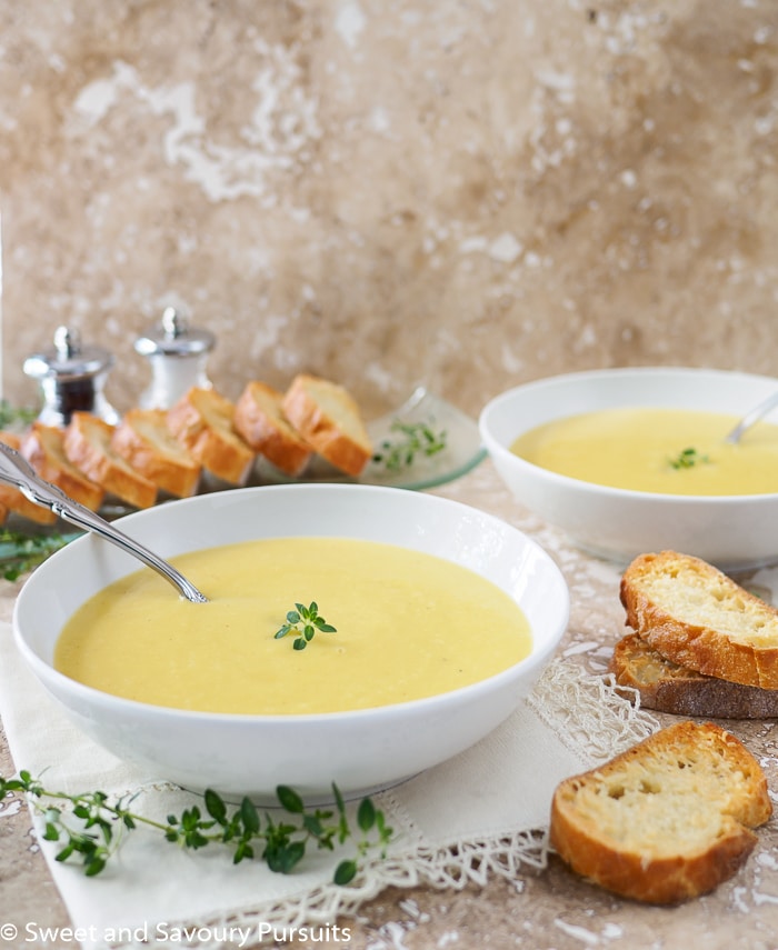 Bowls of Creamy Leek and Potato Soup served with Garlic Parmesan Crostini on the side.