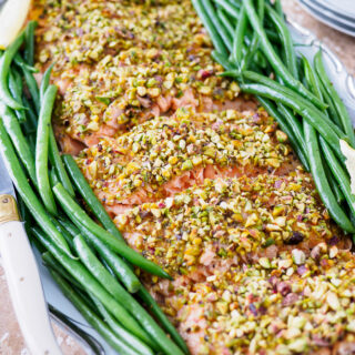 Fillet of Pistachio Crusted Salmon and green beans on serving dish.