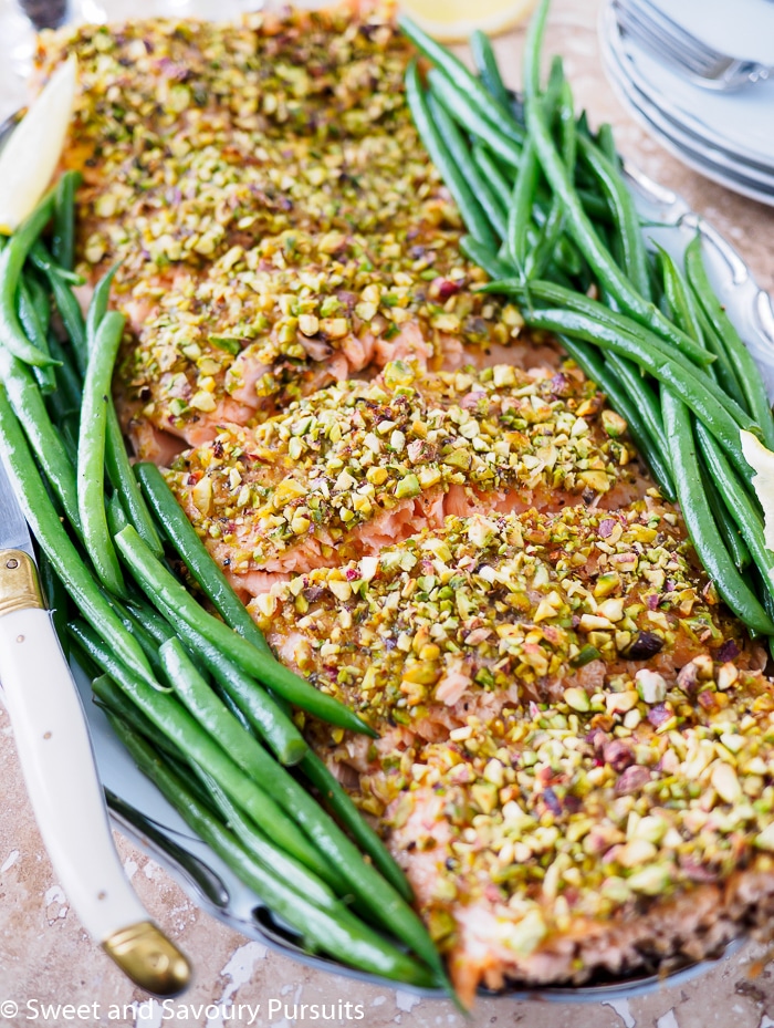 Filet of Pistachio Crusted Salmon and green beans on serving dish.