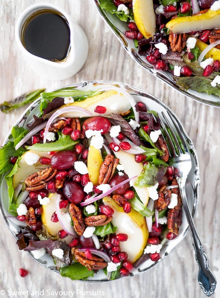 Holiday Winter salad with pear slices, pomegranate arils, grapes and spiced pecans.
