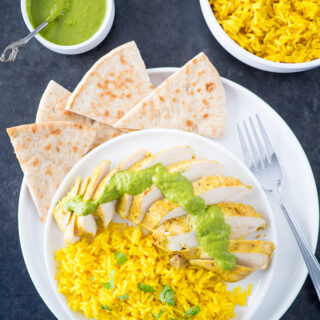 Yogurt marinated chicken breasts served with turmeric rice.