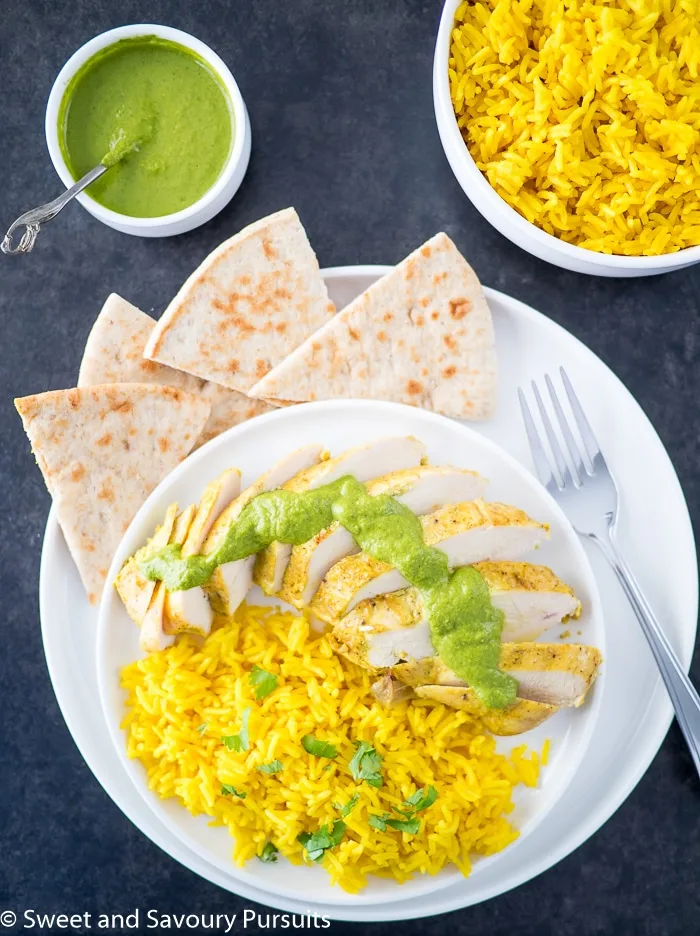 Yogurt marinated chicken breasts served with turmeric rice.